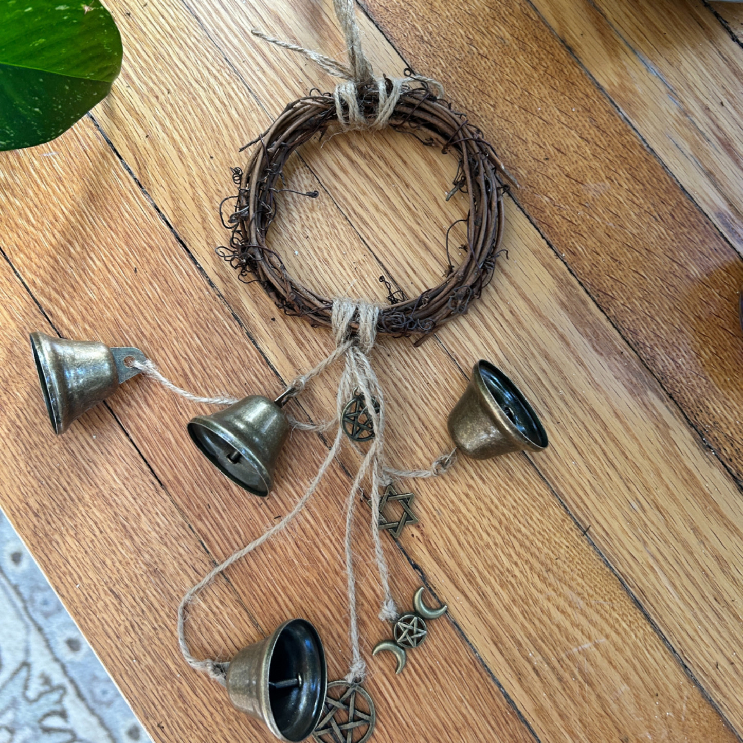 Decorative hanging with bells and twine on a wooden floor