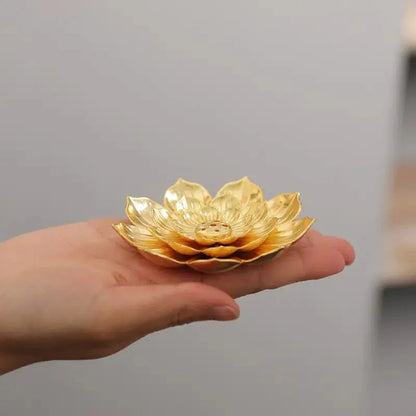 Lotus shaped golden incense burner holder on palm