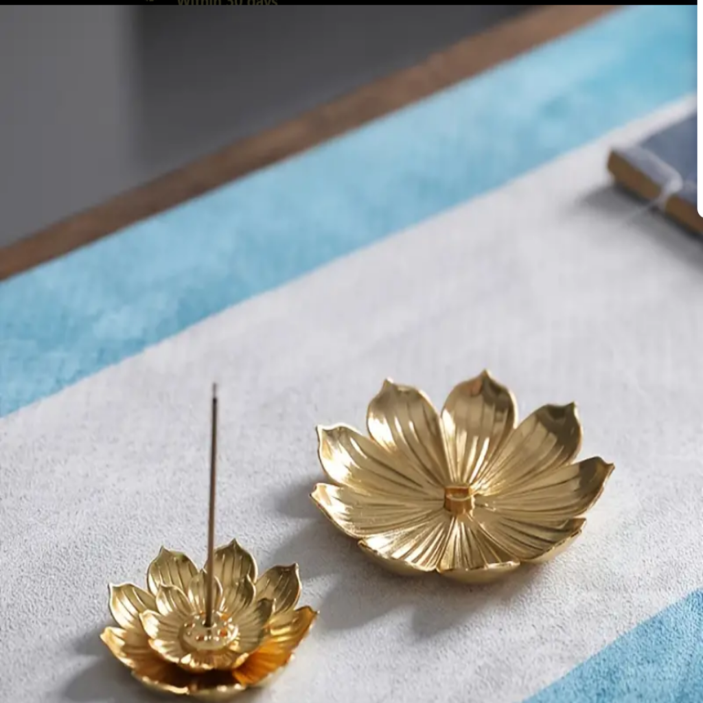 Lotus shaped golden incense holder on table