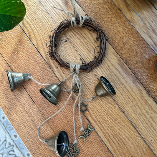 Decorative hanging with bells and twine on a wooden floor