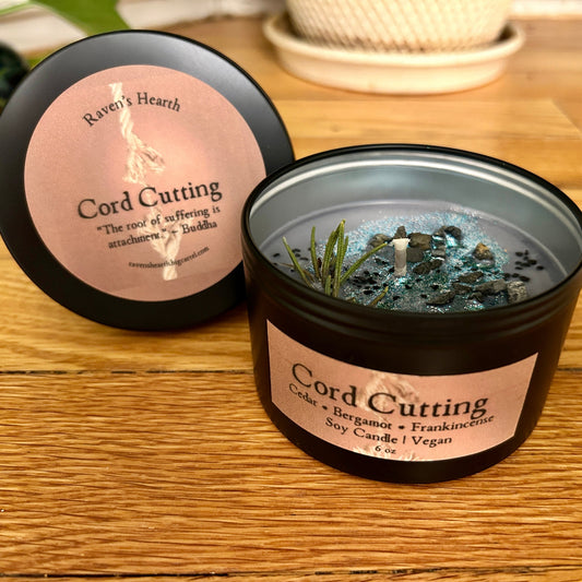 Candle labeled 'Cord Cutting' with rosemary on a wooden surface