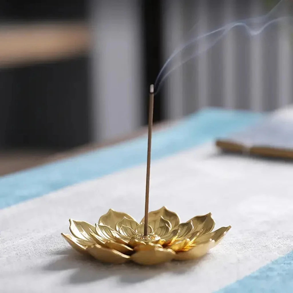 lotus shaped golden incense burner with burning incense stick